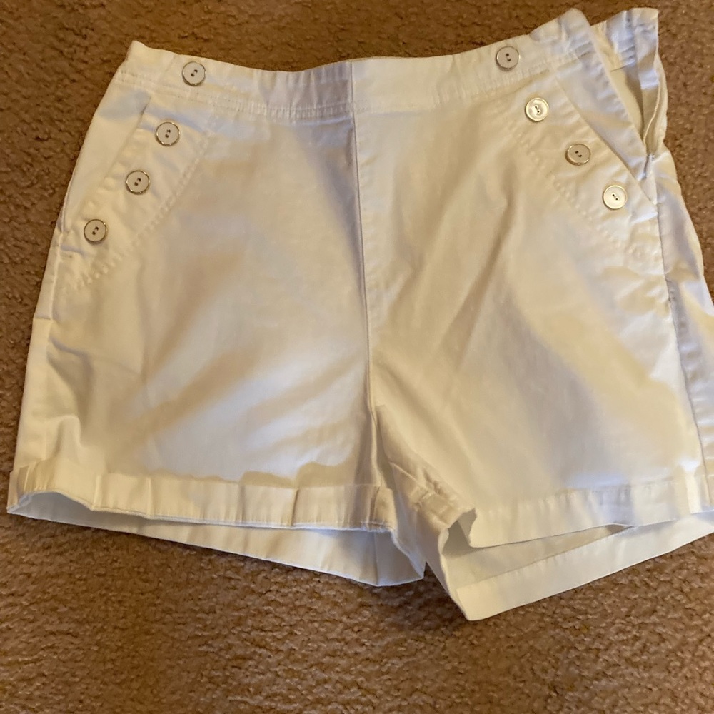 White shorts with side zipper and decorative buttons on each side